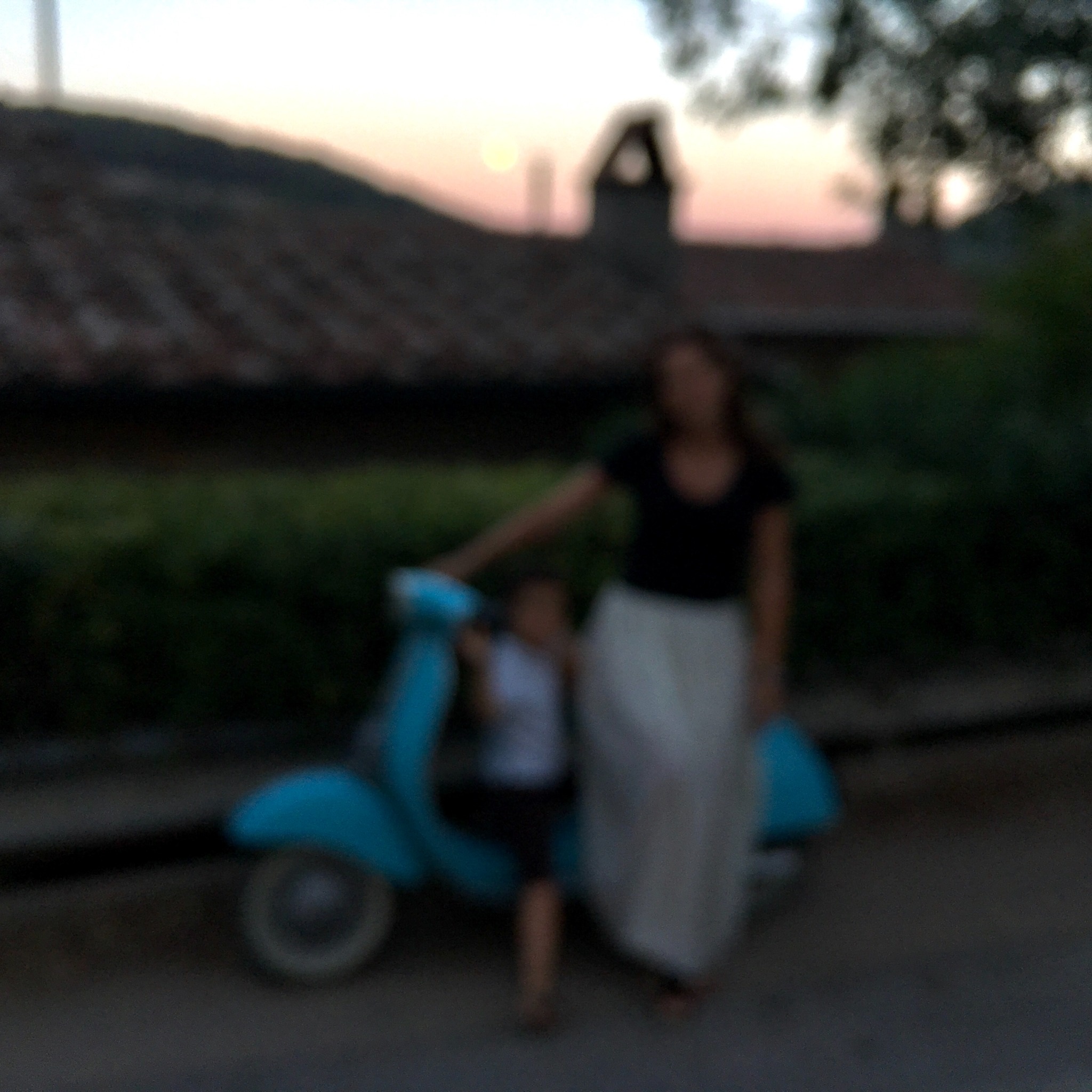 Une présence floue près d’un scooter bleu